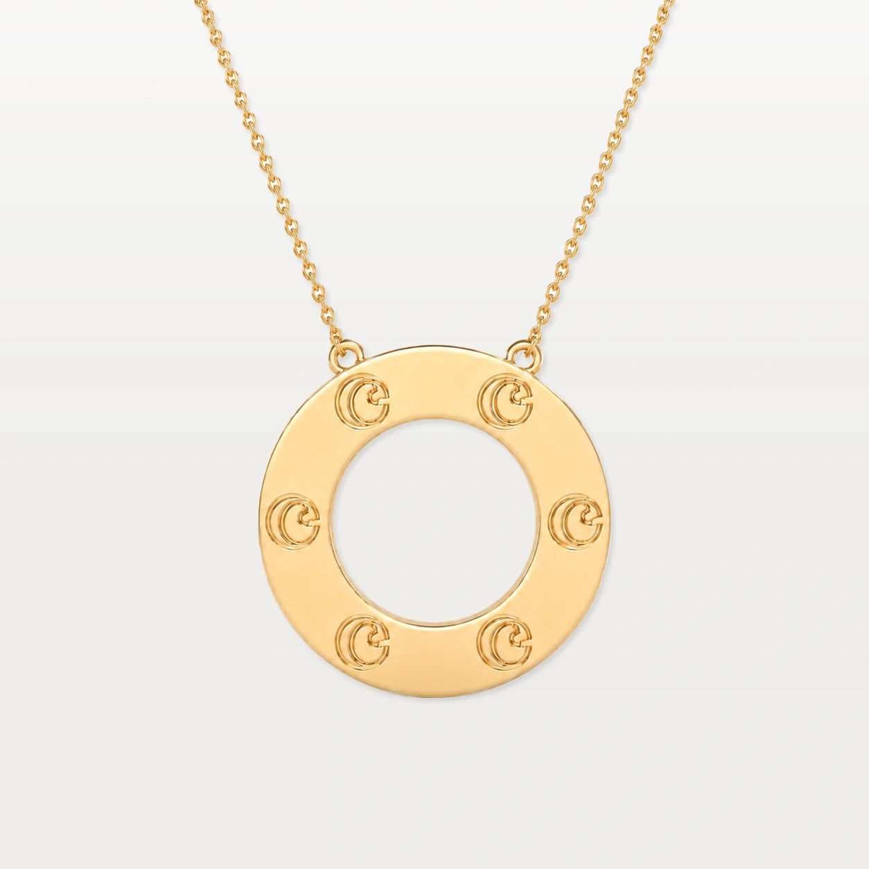 Gold pendant necklace with circular design and decorative elements.